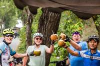 Cyclists enjoying a refreshing coconut roadside in Vietnam |  <i>Lachlan Gardiner</i>