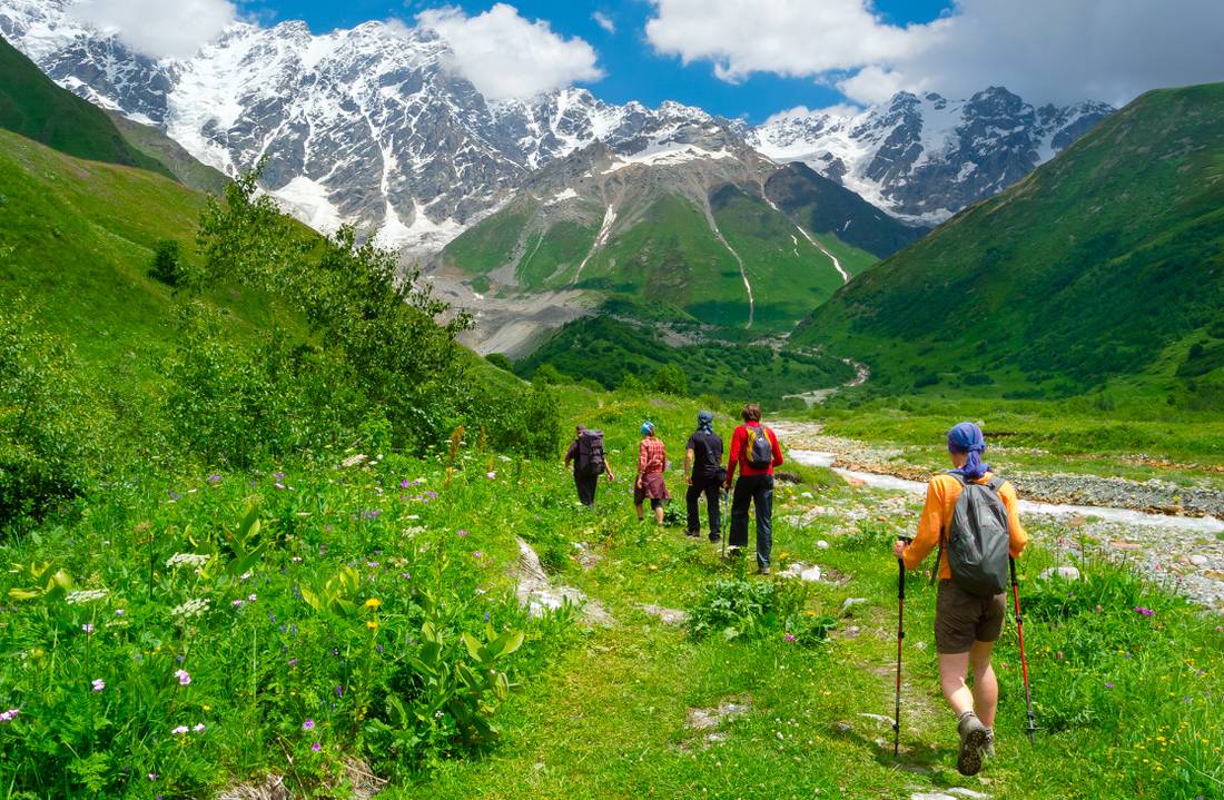 Trekkers enjoying the expansive mountain scenery in Georgia.
