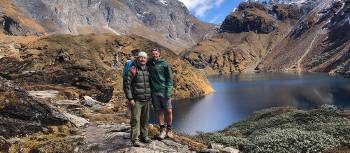 A trekker and guide pose in front of lake Om Tsho on the Bhutan Snowman Trek | Matt Brazier